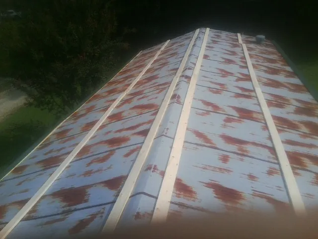 Rusted metal roof panels with new wood purlins before replacement — Storm Damage Roof Repair in Homeland by Roofing Brothers